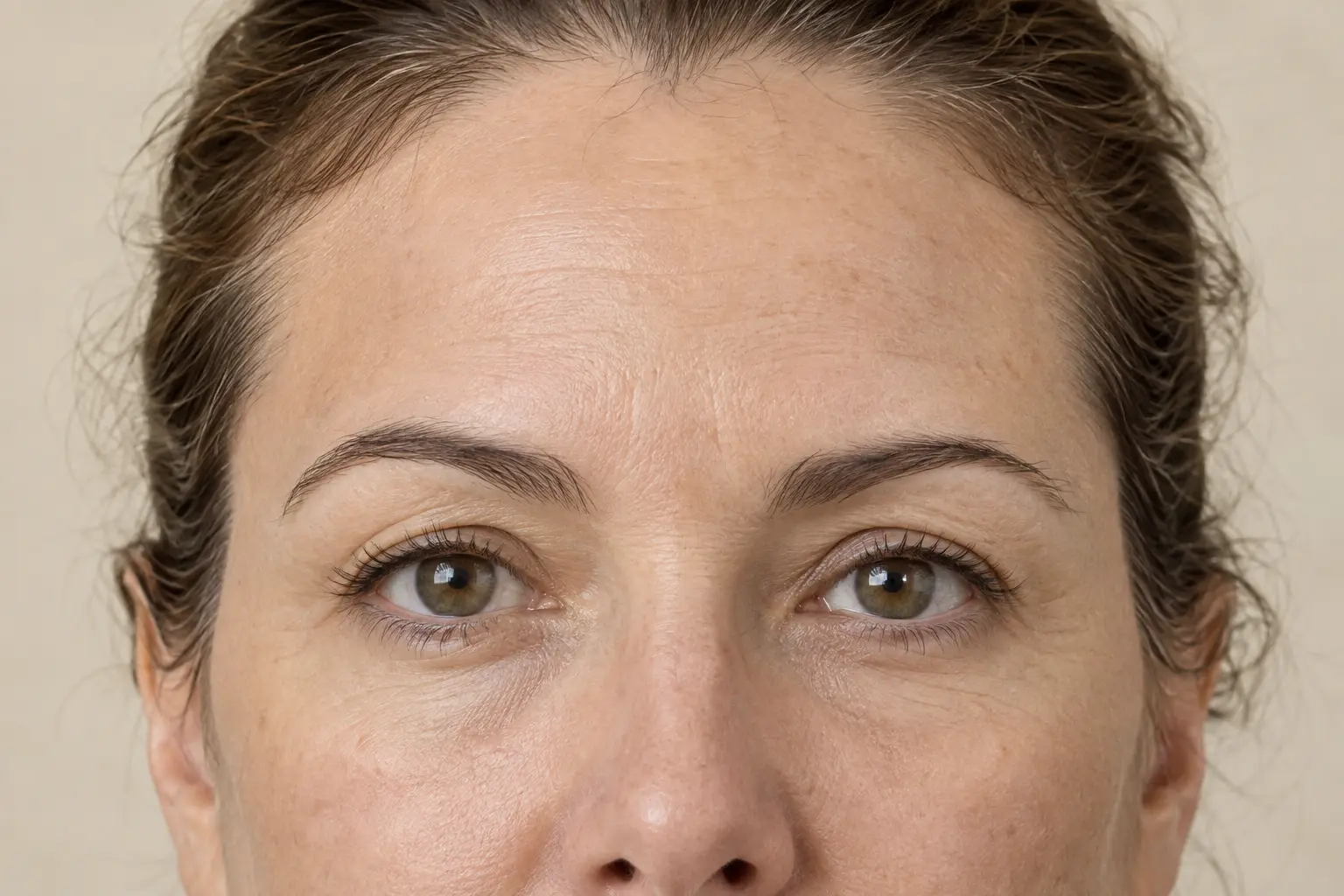 Close observation view of a woman's forehead, brows, and eyes at rest